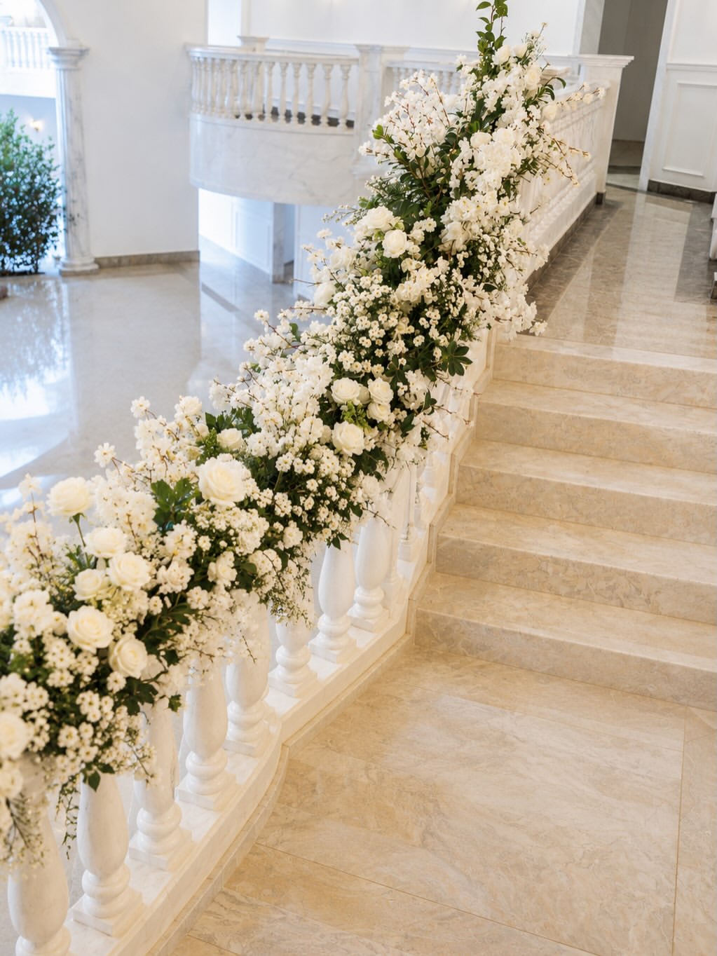 Escadaria de mármore decorada com rosas brancas e mosquitinho